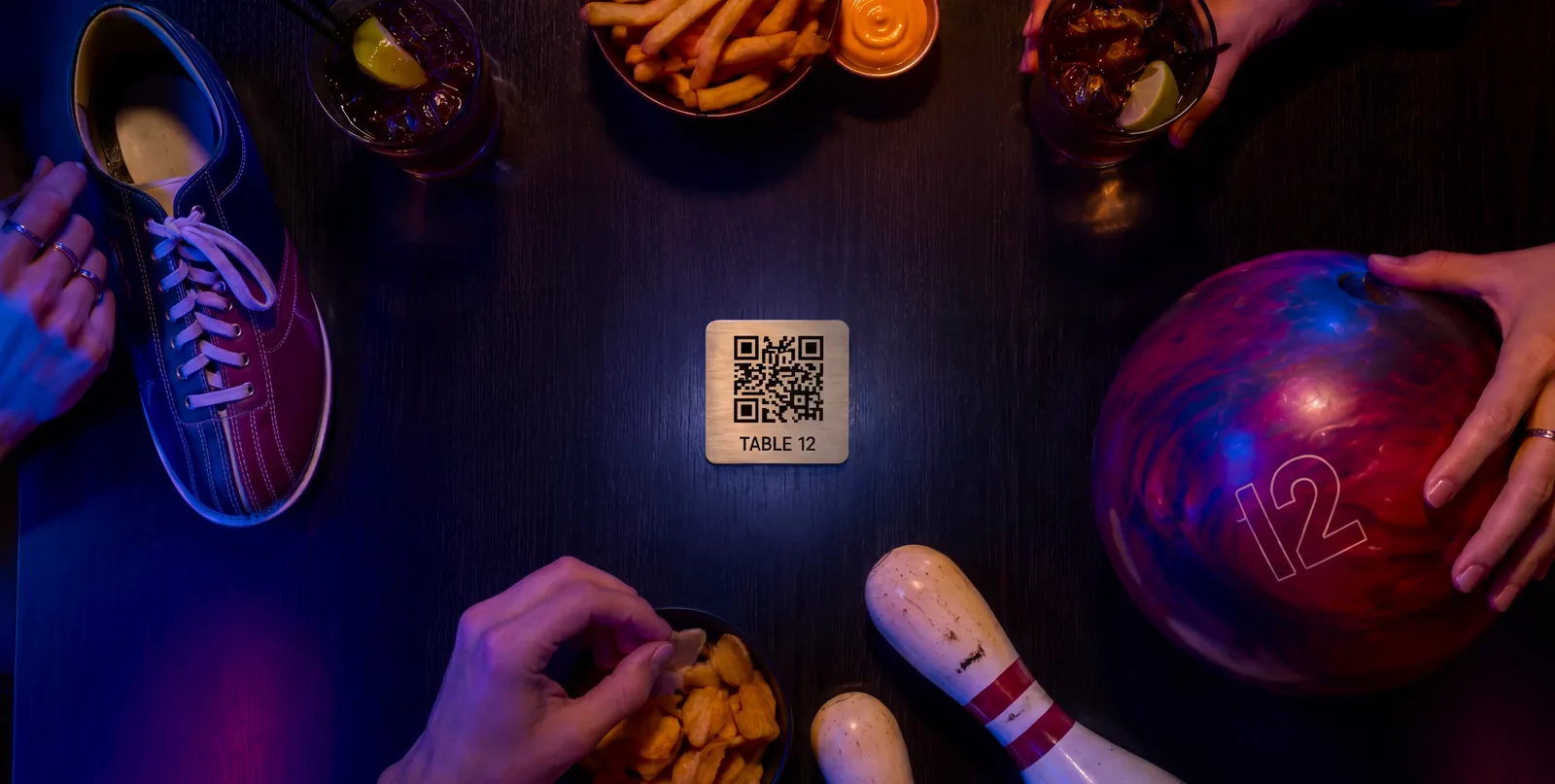 Plaquette QR code en métal sur une table de bowling